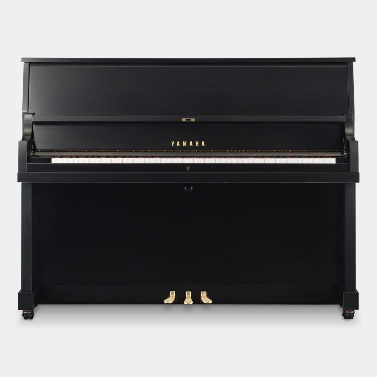 Black Yamaha upright piano with closed lid and visible pedals, ideal for home or studio use.