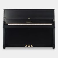 Black Yamaha upright piano with closed lid and visible pedals, ideal for home or studio use.