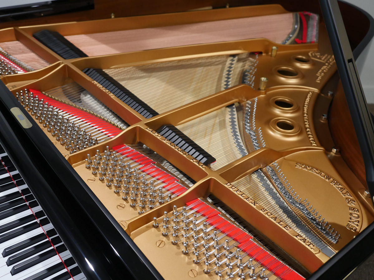 Steinway-lid-open Close-up of a grand piano's intricate interior, showcasing strings and craftsmanship details for music enthusiasts.