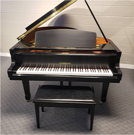 Black grand piano with open lid and matching bench on a carpeted floor.