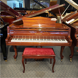 Elegant wooden grand piano with red cushioned bench, showcased in a music store. Perfect for pianists and enthusiasts.